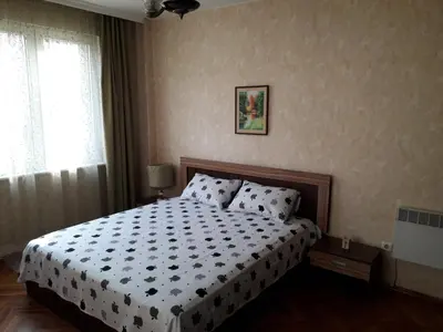 a bedroom with a bed with a black and white comforter at Family style, main street, 20 minutes from the sea in Burgas City