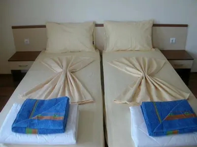 two beds with towels on them in a bedroom at Villa Via Pontica in Sozopol