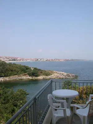 a balcony with a table and chairs and the ocean at Villa Via Pontica in Sozopol