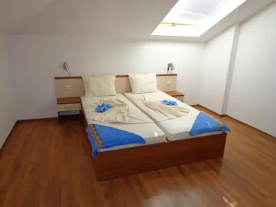 a large bed in a room with a wooden floor at Villa Via Pontica in Sozopol