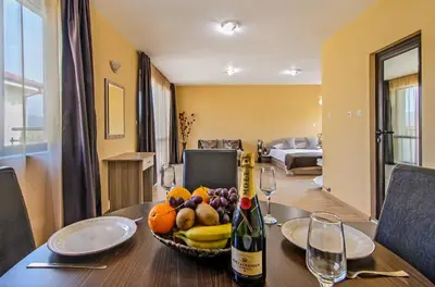 a table with a bowl of fruit and a bottle of wine at Alex Village in Shkorpilovtsi