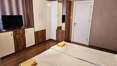 a bedroom with a bed and a tv and a mirror at Green House Apartment in Burgas City
