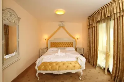 a bedroom with a large bed and a window at Duni Pelican Hotel - All Inclusive in Sozopol