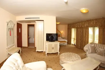 a living room with a couch and a tv at Duni Pelican Hotel - All Inclusive in Sozopol