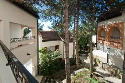 an outside view of a house with a fence and trees at Duni Holiday Village - All Inclusive in Sozopol