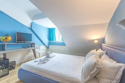 a blue and white bedroom with a bed and a tv at BSA Boulevard Boutique in Sunny Beach
