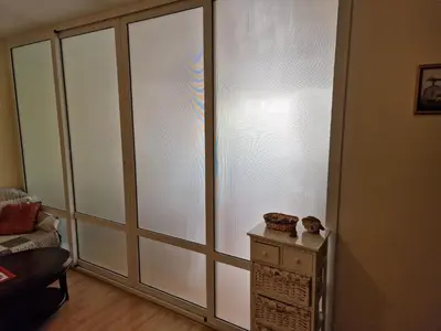 a room with a sliding glass door with a microwave at Słoneczny Brzeg Green Fort Noks Studio in Sunny Beach