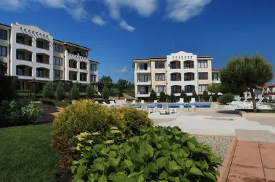 a group of buildings in a courtyard with chairs and plants at View Apartments in Sozopol