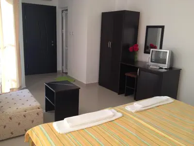 a bedroom with a bed and a desk with a computer at Hotel Paradise in Lozenets