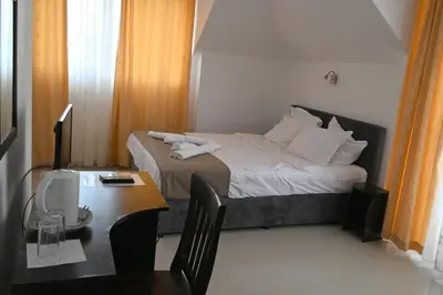 a bedroom with a bed and a desk with a computer at Hotel Paradise in Lozenets