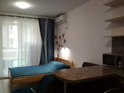 a small bedroom with a bed and a window at Виктория in Pomorie