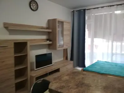 a bedroom with a bed and a tv and a window at Виктория in Pomorie