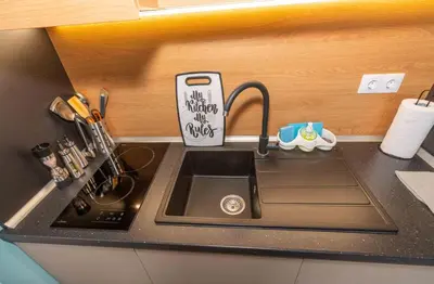 a kitchen counter with a sink and an iphone holder at Pomorie Seaside Apartments in Pomorie