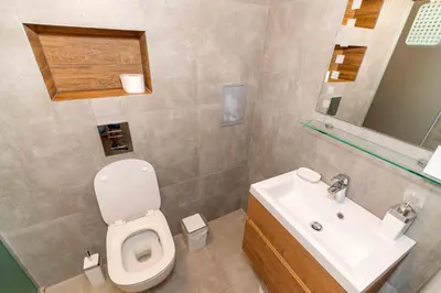 a bathroom with a white toilet and a sink at Pomorie Seaside Apartments in Pomorie
