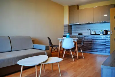 a living room with a couch and a table and a kitchen at Dune Boutique Pomorie in Pomorie