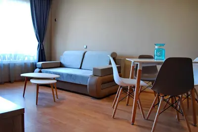a living room with a couch and tables and chairs at Dune Boutique Pomorie in Pomorie