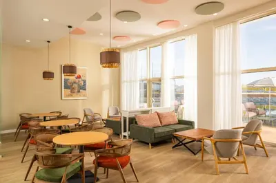 a living room with tables and chairs and a couch at AluaSoul Sunny Beach - Adults Only - All Inclusive in Sunny Beach