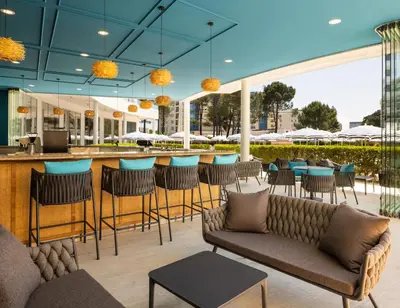 a restaurant with a bar with chairs and tables at AluaSoul Sunny Beach - Adults Only - All Inclusive in Sunny Beach