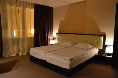 a bedroom with a large bed and a large window at Family Hotel Vaso in Varna City