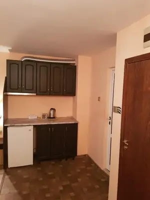 a kitchen with black cabinets and a white refrigerator at Family Hotel Vaso in Varna City