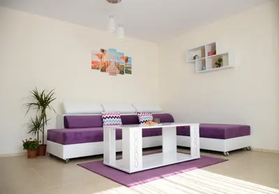 a living room with a purple couch and a table at Rusalka Apart-Residence in Obzor