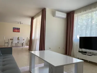 a living room with a white table and a tv at Rusalka Apart-Residence in Obzor