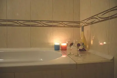 a bathroom with a sink and a candle and wine glasses at Rusalka Apart-Residence in Obzor