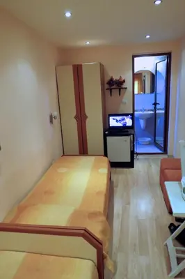 a room with a bed and a tv in it at Family Hotel Lebed in Nesebar