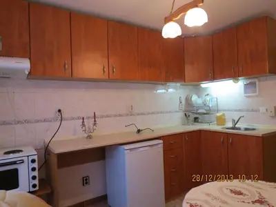 a small kitchen with wooden cabinets and a sink at Family Hotel Lebed in Nesebar