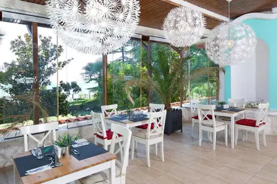 a dining room with tables and chairs and chandeliers at Royal Park Hotel - All Inclusive in Elenite