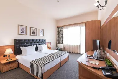 a hotel room with a bed and a desk with a computer at Lotus Family Hotel - Free Parking in Sunny Beach