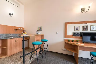 a kitchen with a counter and stools in a room at Lotus Family Hotel - Free Parking in Sunny Beach