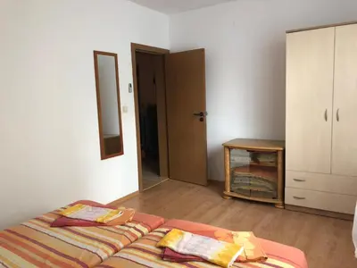 a bedroom with a bed and a closet and a mirror at Комплекс «ТОП» in Sveti Vlas
