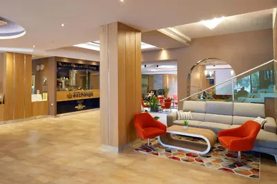 a lobby with a couch and two red chairs at Diamond Hotel - All Inclusive in Sunny Beach