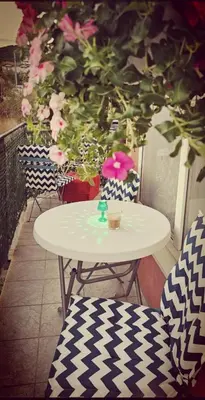 a white table and chairs on a balcony with flowers at Apartment Blue Komfort in Sunny Beach