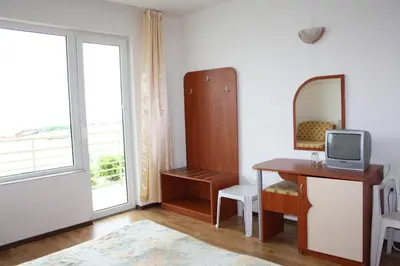 a room with a desk and a mirror and a window at Harmony Beach Family Hotel in Nesebar