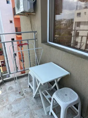 a white table and a stool next to a window at Къща Нанси in Sunny Beach