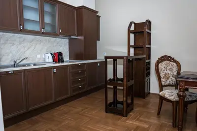 a kitchen with wooden cabinets and a table and chairs at Long Beach Resort in Shkorpilovtsi