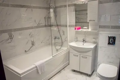 a bathroom with a tub and a sink and a toilet at Long Beach Resort in Shkorpilovtsi