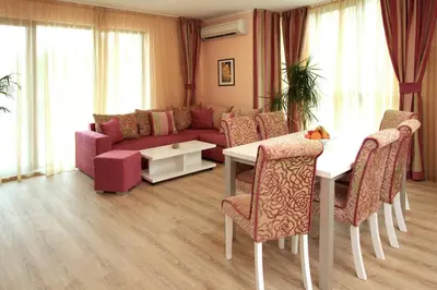 a living room with a couch and a table and chairs at Long Beach Resort in Shkorpilovtsi