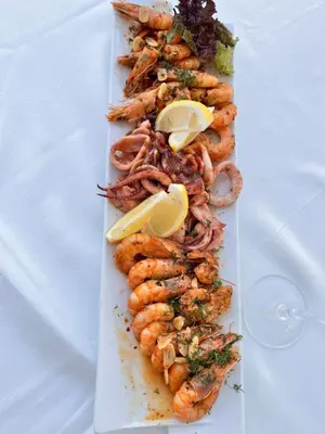 a white plate with shrimp on a white table at Mirage Hotel in Nesebar