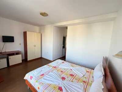 a bedroom with a bed and a television in it at Lilia Guest House in Nesebar