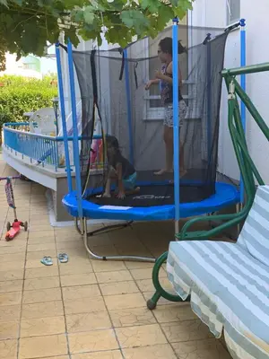 a man and a child playing in a trampoline at Lilia Guest House in Nesebar