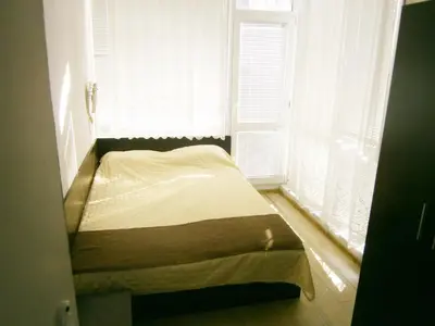 a small bed in a room with a window at Family Hotel White House in Pomorie