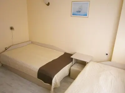 a small bedroom with two beds and a table at Family Hotel White House in Pomorie