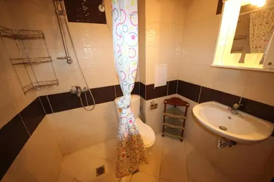 a bathroom with a shower curtain and a toilet and a sink at Amadeus Lux - Menada Apartments in Sunny Beach