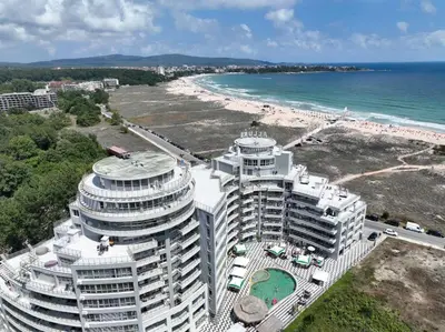 a large building on the beach next to the ocean at Allure Beach Resort Aparthotel in Primorsko