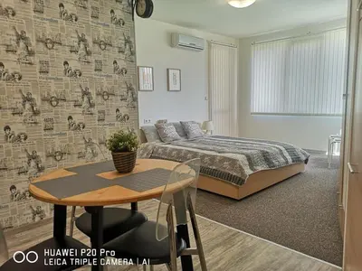 a bedroom with a bed and a table in front of a bed at Apartment SeaGarden 19 in Varna City