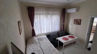 a room with a bed and a table and a window at Burgas Central-Sheynovo in Burgas City