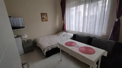 a room with a bed and a table with red plates on it at Burgas Central-Sheynovo in Burgas City